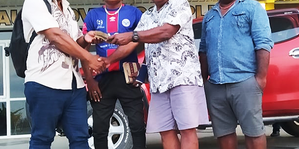 Hon Stanley Sofu hands over the money to the Waneagu FC Management. Photo Waneagu FC media