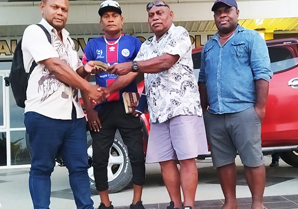 Hon Stanley Sofu hands over the money to the Waneagu FC Management. Photo Waneagu FC media