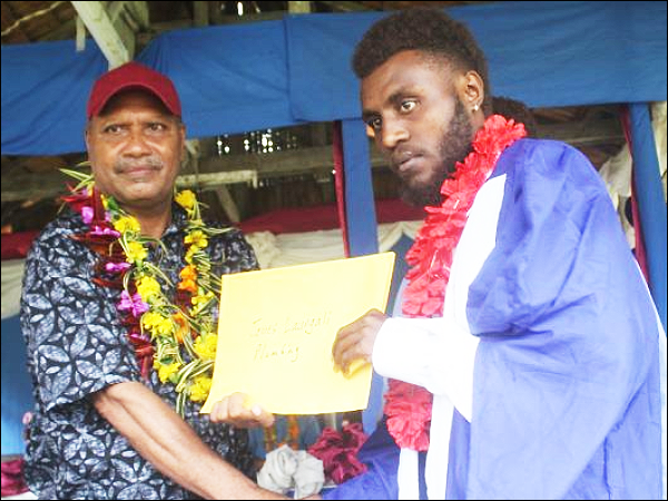 A plumbing student receives his certificate from Premier Suidani.