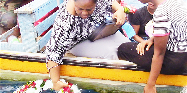 A family member laying a wreath in the ocean.