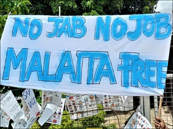 Protestors pin up banners with slogans at the Malaita Provincial Admin office