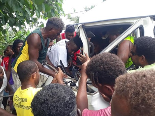 Onlookers removing bus doors to assist the passengers.