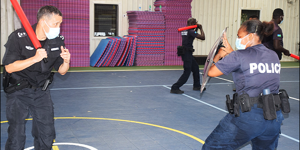 A Chinese police officer trainin a RSIPF female officer on how to use the shield. (Photo supplied)