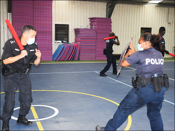A Chinese police officer trainin a RSIPF female officer on how to use the shield. (Photo supplied)