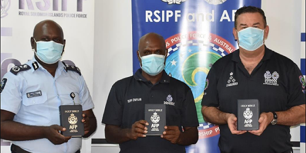 Deputy Commissioner Ian Vaevaso, Chaplain Melden Hall and Commander Paul Osborne display the Bibles. Photo supplied.