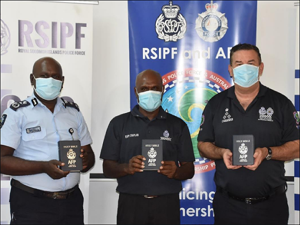 Deputy Commissioner Ian Vaevaso, Chaplain Melden Hall and Commander Paul Osborne display the Bibles. Photo supplied.