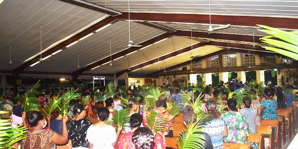 St. Barnabas congregants raising their palms for the blessing of the palms and crosses.