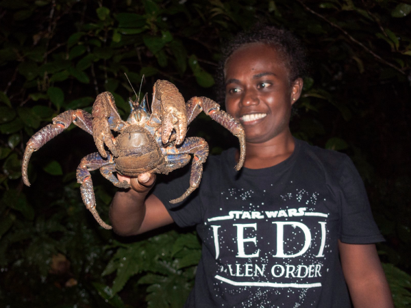 A guide handling a coconut crab at Tetepare.