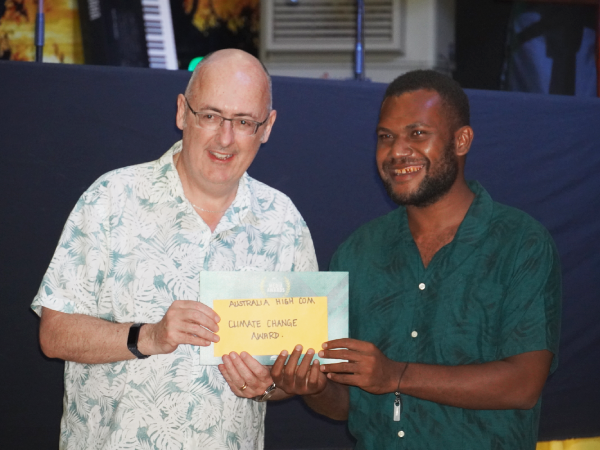 Jeremy Gwao won the award for Excellence in Climate Change Reporting Award, receiving his award from the Australian High Commissioner, Dr. Lachlan Strahan.