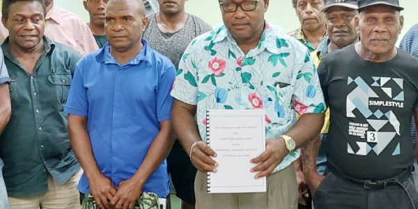 Members of the Aluta Basin landowning tribes pose with their Member of Parliament and Deputy Prime Minister, Manasseh Maelanga, as he shows a copy of land documents presented to him. The presentation was witnessed by the Deputy Secretary of MAL, Michael Ho’ota and MCILI Deputy Secretary-Technical, George Eric.