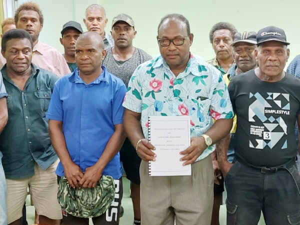 Members of the Aluta Basin landowning tribes pose with their Member of Parliament and Deputy Prime Minister, Manasseh Maelanga, as he shows a copy of land documents presented to him.  The presentation was witnessed by the Deputy Secretary of MAL, Michael Ho’ota and MCILI Deputy Secretary-Technical, George Eric.