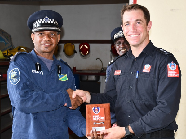 FRNSW Leading Firefighter, Jordan, presenting a gift to the RSIPF’s Fire and Rescue Services’ Dekyi.