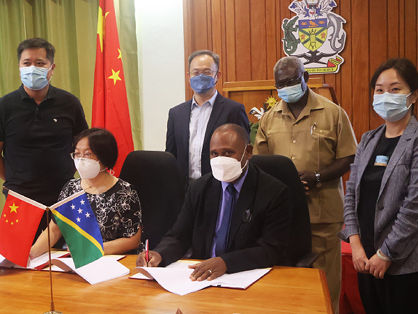 Representing PRC, Councillor Gong Rui and representing the government, Health Minister Dr Culwick Togamana signing the agreement witnessed by PM Sogavare and PRC ambassador Li Ming