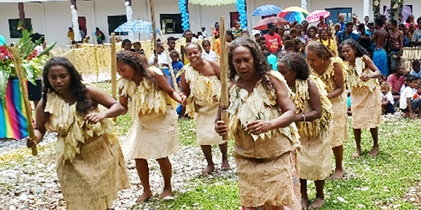 Santa Isabel cultural group putting on an item in front of the new classroom block.