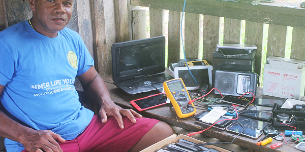 Michael Wale with some of faulty Mobile phone devices at his home in Auki.