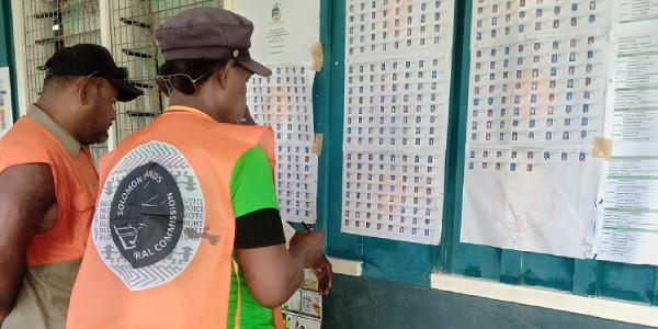 Polling officials assisting voters check for their names during the last by-elections.