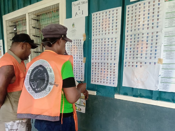 Polling officials assisting voters check for their names during the last by-elections.