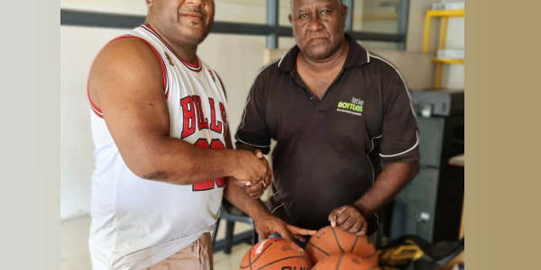 SKBA Coach and co-founder Mr Moses Kivo hands over the basketballs to Central Province rep Mr Michael Kuali.