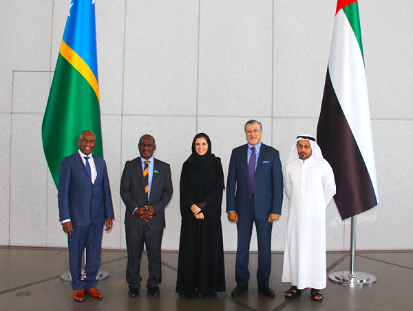 Minister Jeremiah Manele and Ambassador Moses Kouni Mose proudly stand in front of the Solomon Islands and the UAE flag with Her Excellency Hana AlHashimi, Senior Adviser H.E. Dr Adnan Z Amin & Mr.Mohammed Alblou.