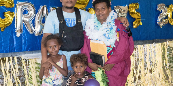 Grinta George being congratulated by her son Gerhard Paia along with his two kids standing in front.