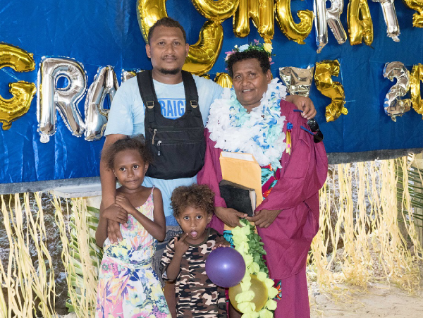 Grinta George being congratulated by her son Gerhard Paia along with his two kids standing in front.