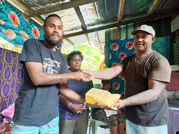 OMS Daniel Kakadi hands over their donation to Rosemary Kelesi’s parents.