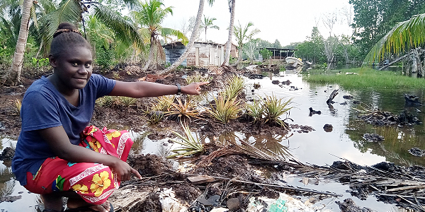 Betina Taki pointing and raising her concern about the future of sea level rise.