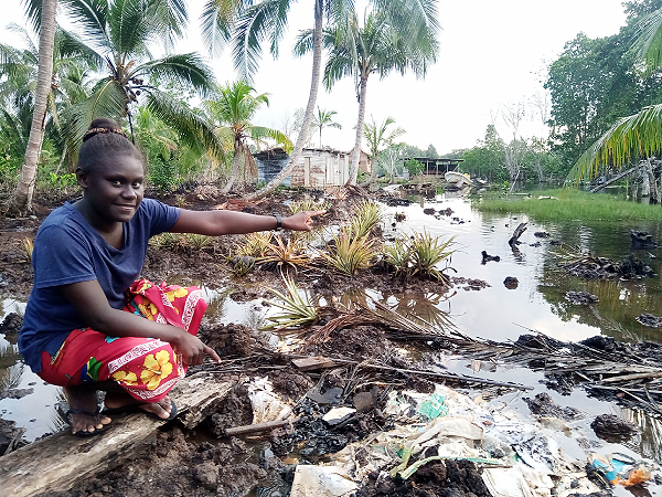 Betina Taki pointing and raising her concern about the future of sea level rise.