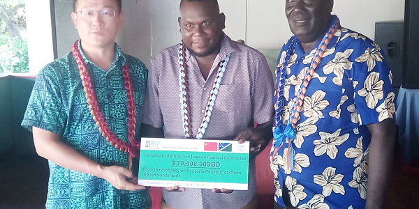 PRC Ambassador, Li Ming and Western Province Minister of Culture and Tourism, Ron Ghemu and Premier, Billy Veo, displaying a mock cheque of the $70K assistance from PRC.