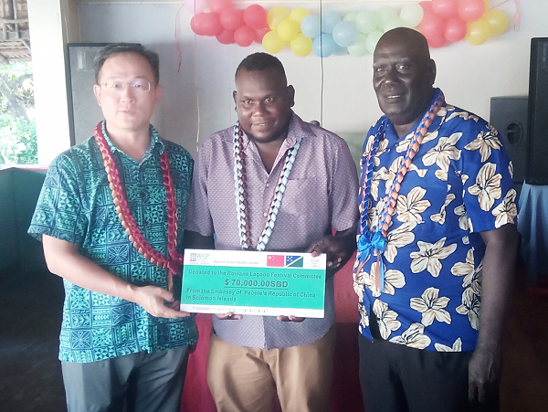 PRC Ambassador, Li Ming and Western Province Minister of Culture and Tourism, Ron Ghemu and Premier, Billy Veo, displaying a mock cheque of the $70K assistance from PRC.