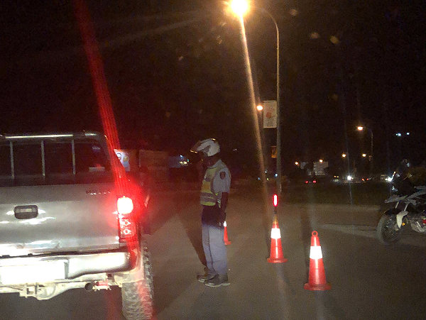 A police officer interacts with a driver during the night traffic checks at the HCC Roundabout.