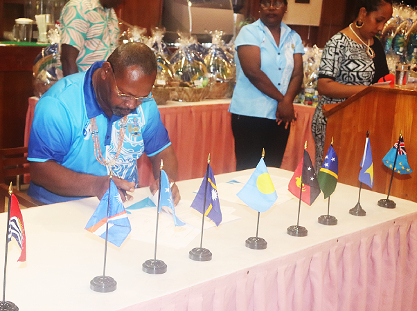 Fisheries Minister Nestor Ghiro signs the PNA Communique. Photo, Ministry of Fisheries.