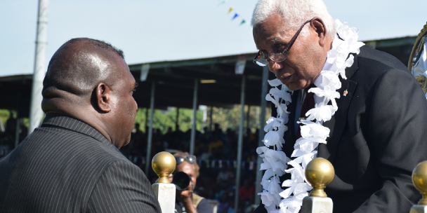 Governor General Sir David Vunagi on the dais converses with Patterson Saeni, the former prisoner who was pardoned during the King’s birthday ceremony, Friday.