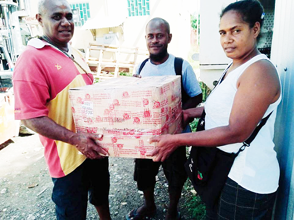 Ward 29 Development Committee Treasurer, Nester Totoramo (right) delivering a project to a project recipient. Photo by Solomon Lofana.