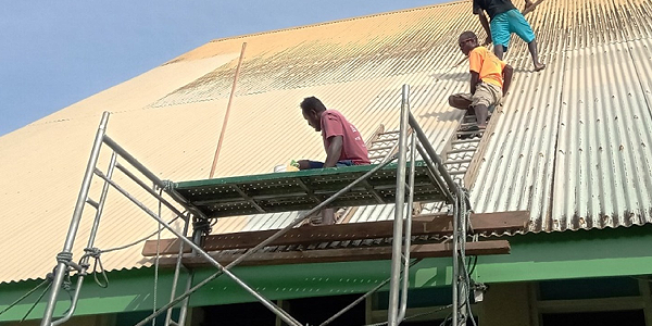 Contractors painting the roof of the new church building.