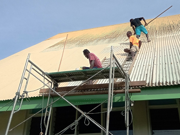 Contractors painting the roof of the new church building.