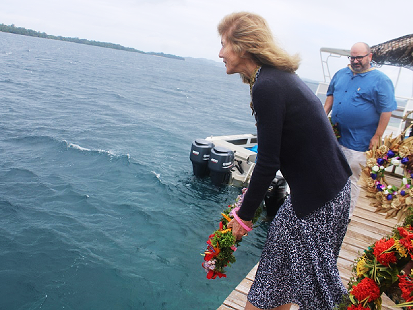Caroline Kennedy tosses a wreath into the ocean at Kennedy island to remember those that lost their lives during WWII.