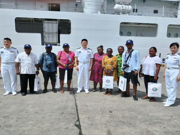 Local reporters with Peace Ark’s Naval Officers after their tour aboard the floating hospital yesterday.