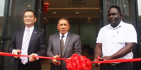 Supervising Minister of Foreign Affairs and External Trade, Hon. Peter Shanel Agovaka, Charge de Affairs of the People’s Republic of China to Solomon Islands, Ding Yonghua and the supervising Permanent Secretary of the Ministry of Foreign Affairs and External Trade, Bunyan Sivoro cutting a ribbon to officially open the consular section in the PRC Embassy.