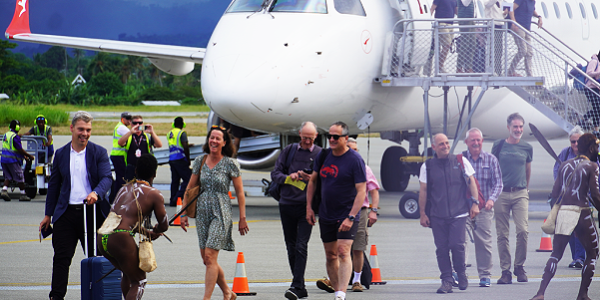 Warriors welcoming passengers disembarking off the first Quantas flight to Honiara.