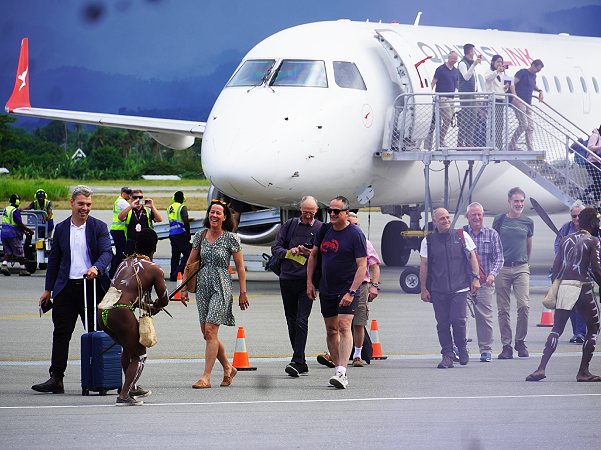 Warriors welcoming passengers disembarking off the first Quantas flight to Honiara.