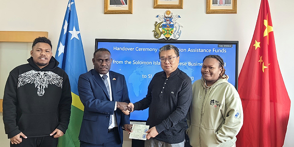 Solomon Islands Ambassador to the Peoples Republic of China, H.E Barrett Salato receiving the assistance from SCBC Representative, Mr. Ze Liu. Looking on is Solomon Islands students, Tony Sutahi and Ms. Kate Gwaena.
