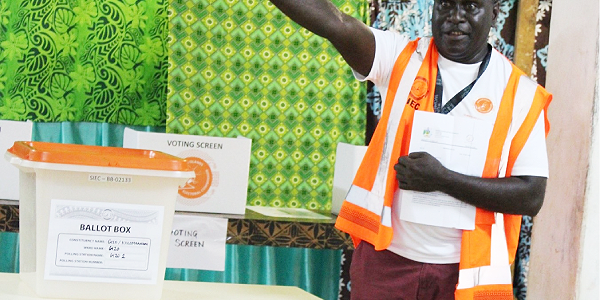 Election Manager Collin Potakana with the old ballot box and the legal instrument authorizing its reusage.