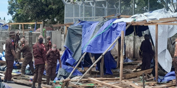 HCC officers dismantling market stalls.