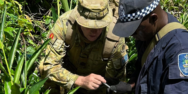 ADF EOD Advisor and PC Roau record information on a UXO stack. Photo, RSIPF Media.