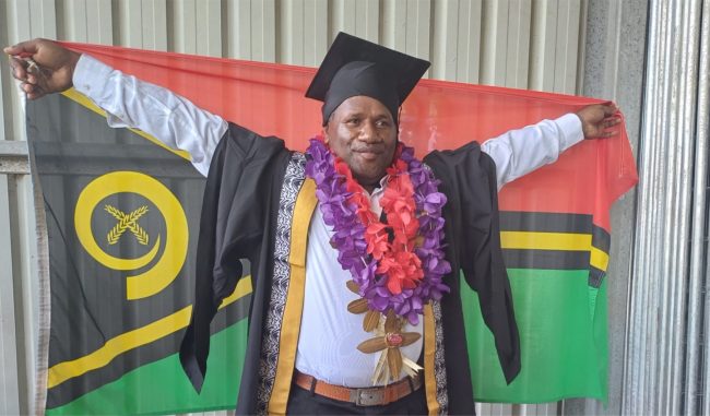 John Anadiere Saur from Vanuatu proudly displaying his national flag after the SINU graduation ceremony