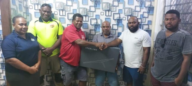 The new Starlink Satelite disk handed by Noel Nelu (third from right) to Bruce Palusi while members of both committees and the Temotu Premier Stanley Tehiahua (center) look on