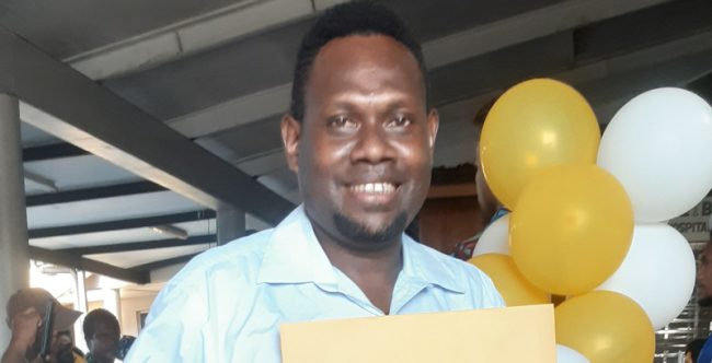 Chris Jnr Sade holding his High Achiver Award.