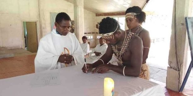 Fr Keku witnessing the signing of marriage certificate by the groom. Photo supplied