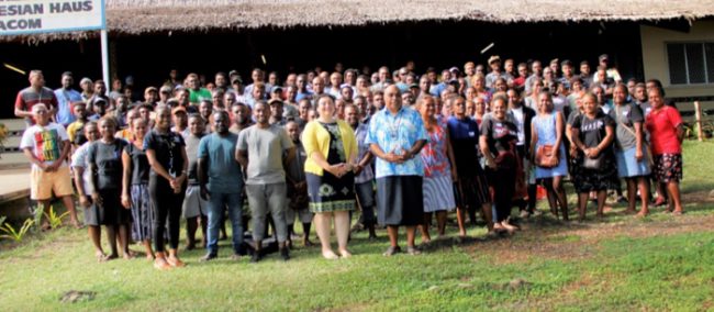 MFAET PS Colin Beck and an official from the Australian High Commission posing with a group of PALM workers